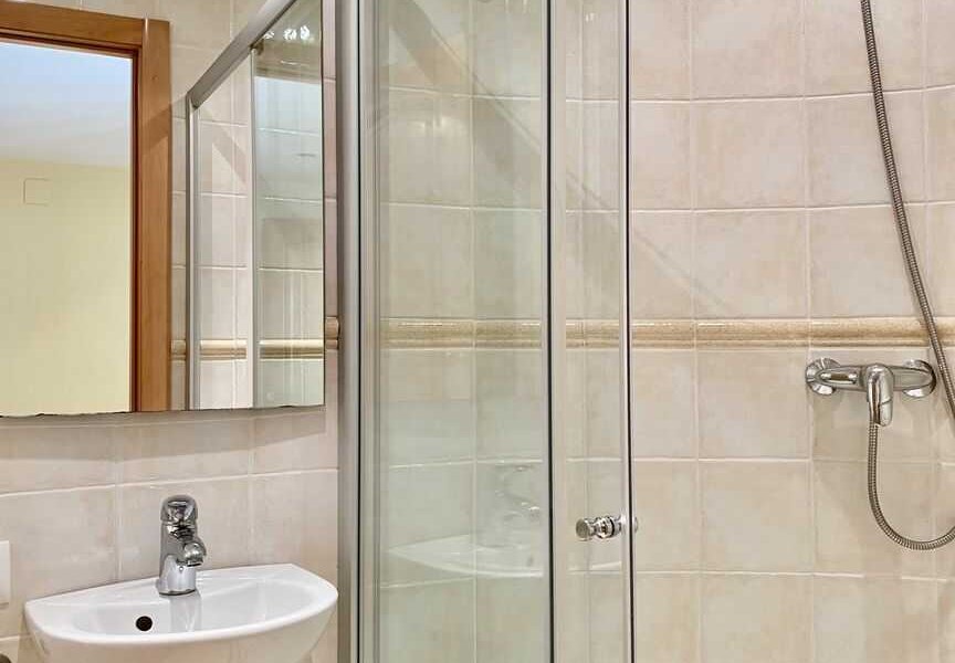 Badezimmer mit Dusche, Waschbecken und Toilette im Haus