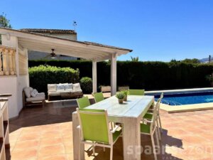 Grillplatz mit großem Esstisch auf der Terrasse der Villa mit Blick auf den Pool