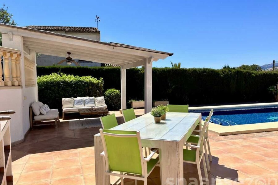Grillplatz mit großem Esstisch auf der Terrasse der Villa mit Blick auf den Pool