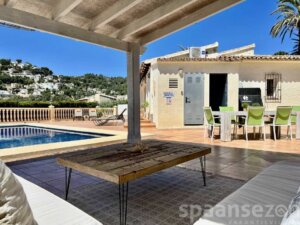 Überdachter Loungebereich mit Blick auf den Pool und die Berge von Moraira