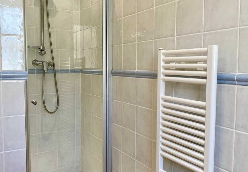Badezimmer mit Dusche, Waschbecken und Toilette im Haus