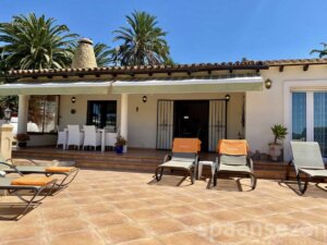 überdachte Terrasse mit Esstisch und Blick auf den Pool in Moraira