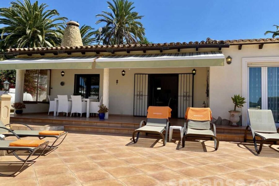 überdachte Terrasse mit Esstisch und Blick auf den Pool in Moraira