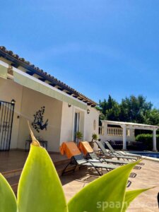 überdachte Terrasse mit Esstisch und Blick auf den Pool in Moraira