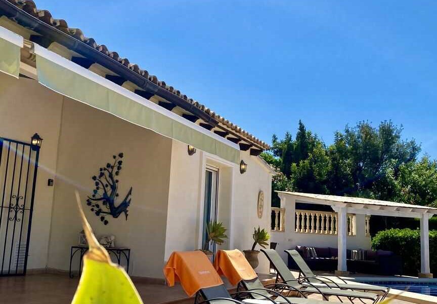 überdachte Terrasse mit Esstisch und Blick auf den Pool in Moraira